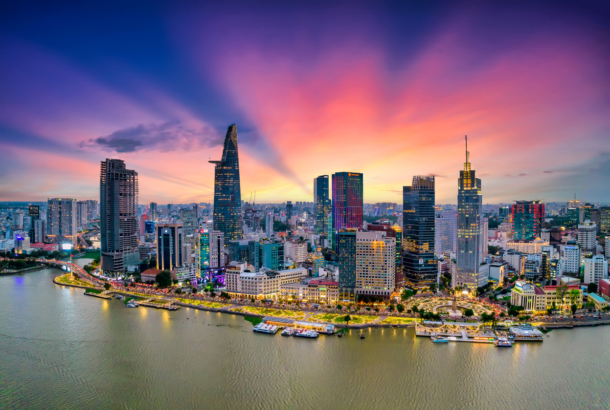 Panorama moderner Hochhäuser entlang des Flusses mit farbigem Abendhimmel in Ho-Chi-Minh-Stadt, Vietnam.