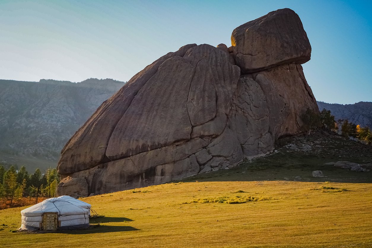 Schildkrötenförmiger Granitfelsen und Jurte auf Steppe im Gorkhi-Terelj Nationalpark.