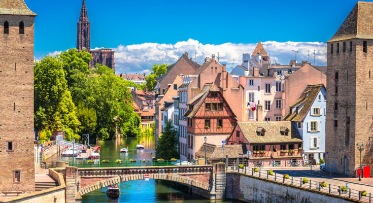 Panoramablick auf Fachwerkhäuser, Kanal und Straßburger Münster in der Petite France.