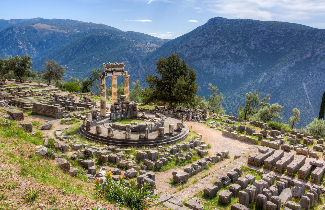 Antike Rundtempel-Ruine in Delphi vor den grünen Parnass-Bergen.