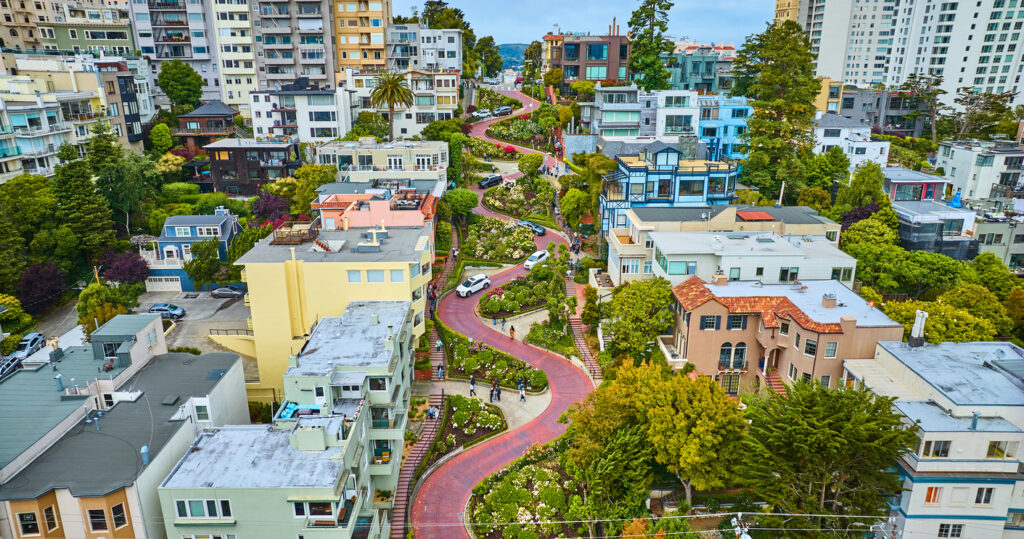 Luftaufnahme der Lombard Street mit acht engen, blumenbepflanzten Serpentinen zwischen Wohnhäusern in San Francisco.