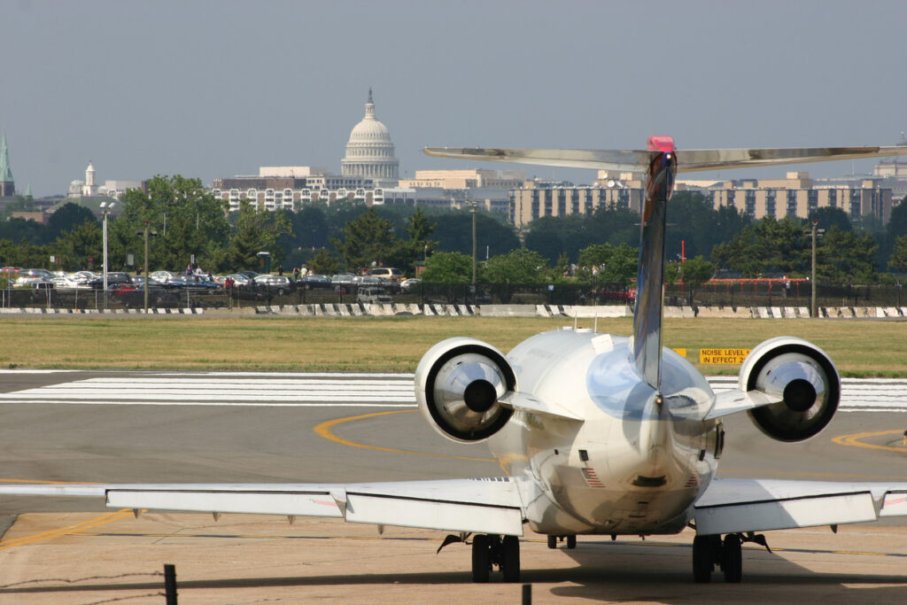 Verkehrsflugzeug auf dem Rollfeld in Washington, D.C., mit der Kuppel des US-Kapitols im Hintergrund als Symbol für Flüge aus Deutschland.