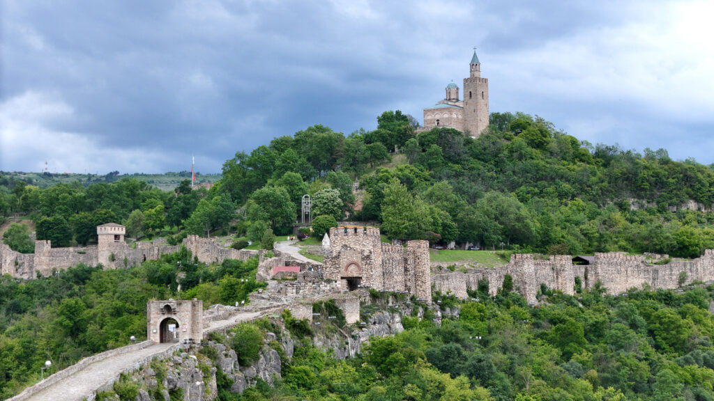 Panoramablick auf die mittelalterliche Festung Zarewez mit Toren, Mauern und Patriarchenkirche auf einem bewaldeten Hügel.