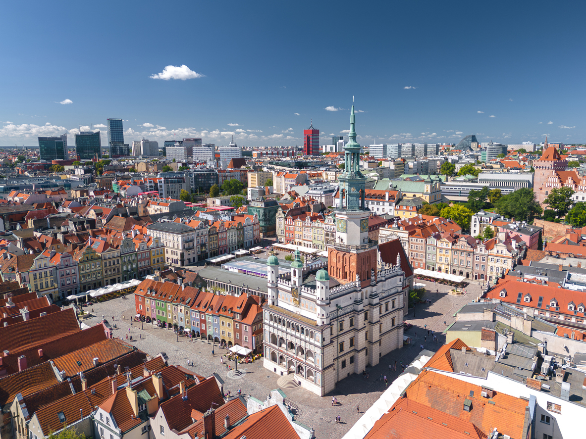 Luftaufnahme des Alten Marktes in Posen mit weißem Renaissancerathaus und bunten Bürgerhäusern.