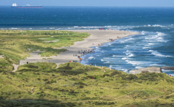 Schmale Sandzunge bei Skagen mit Spaziergängern, Dünen und sich treffenden Wellen zweier Meere.
