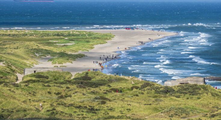 Schmale Sandzunge bei Skagen mit Spaziergängern, Dünen und sich treffenden Wellen zweier Meere.
