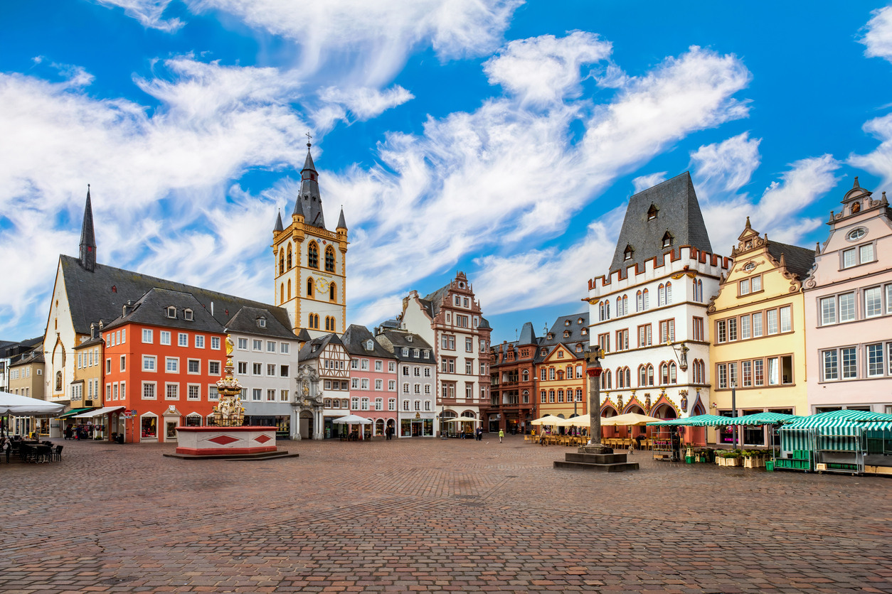 Historischer Platz mit bunten Bürgerhäusern, Marktkreuz und St.-Gangolf-Kirchturm.