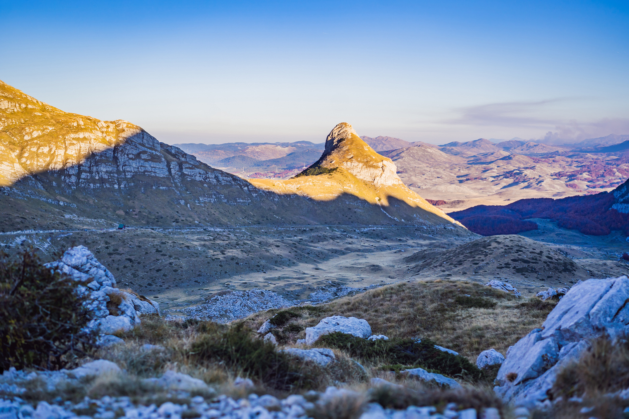 Weite Berglandschaft im Durmitor-Nationalpark bei Žabljak mit freistehendem Felsgipfel, Karstplateau und Fernblick unter klarem Himmel.