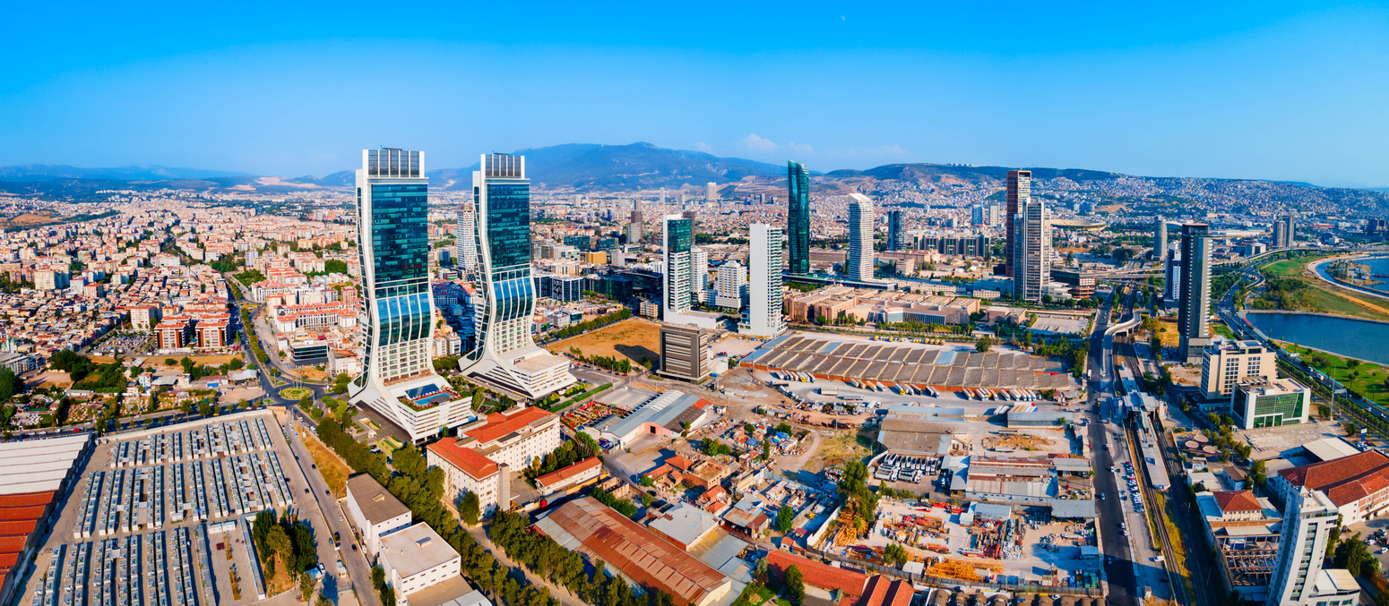 Luftblick auf İzmir mit geschwungenen Zwillingstürmen, Hafen und Bergen