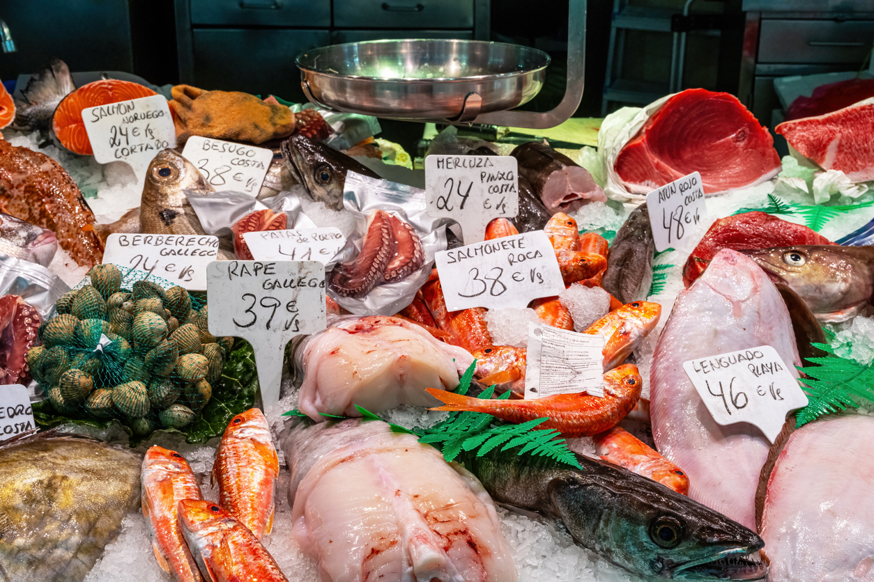 Ein reich bestückter Marktstand in Barcelonas La Boqueria zeigt Fische und Meeresfrüchte auf Eis mit handgeschriebenen Preisschildern.