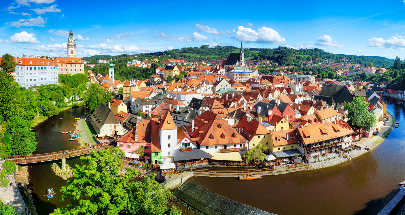 Panoramablick auf Český Krumlov mit roten Dächern, Burgturm und Moldauschleife.