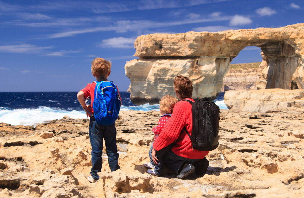 Eine Familie schaut auf den Felsbogen Azure Window am Meer auf Gozo.