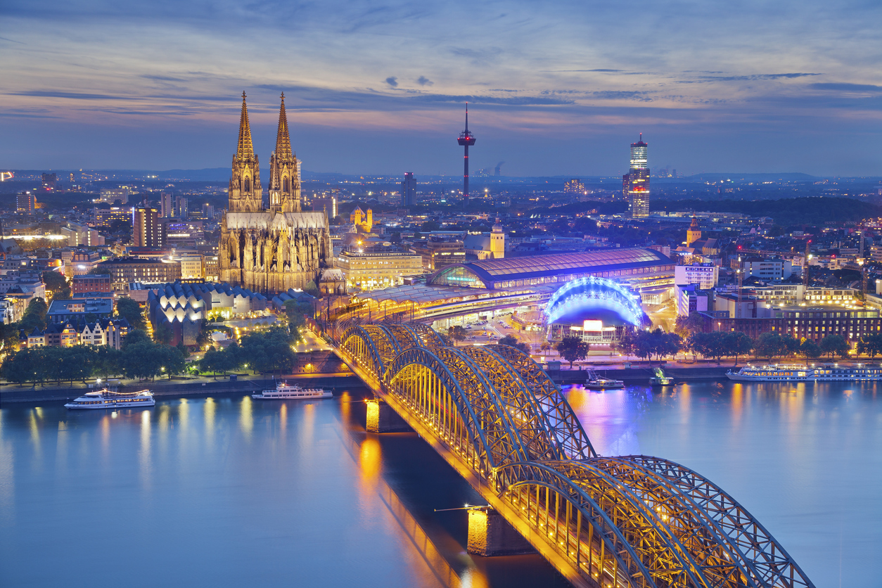 Blick auf Kölner Dom, Hohenzollernbrücke und den Rhein im Abendlicht.