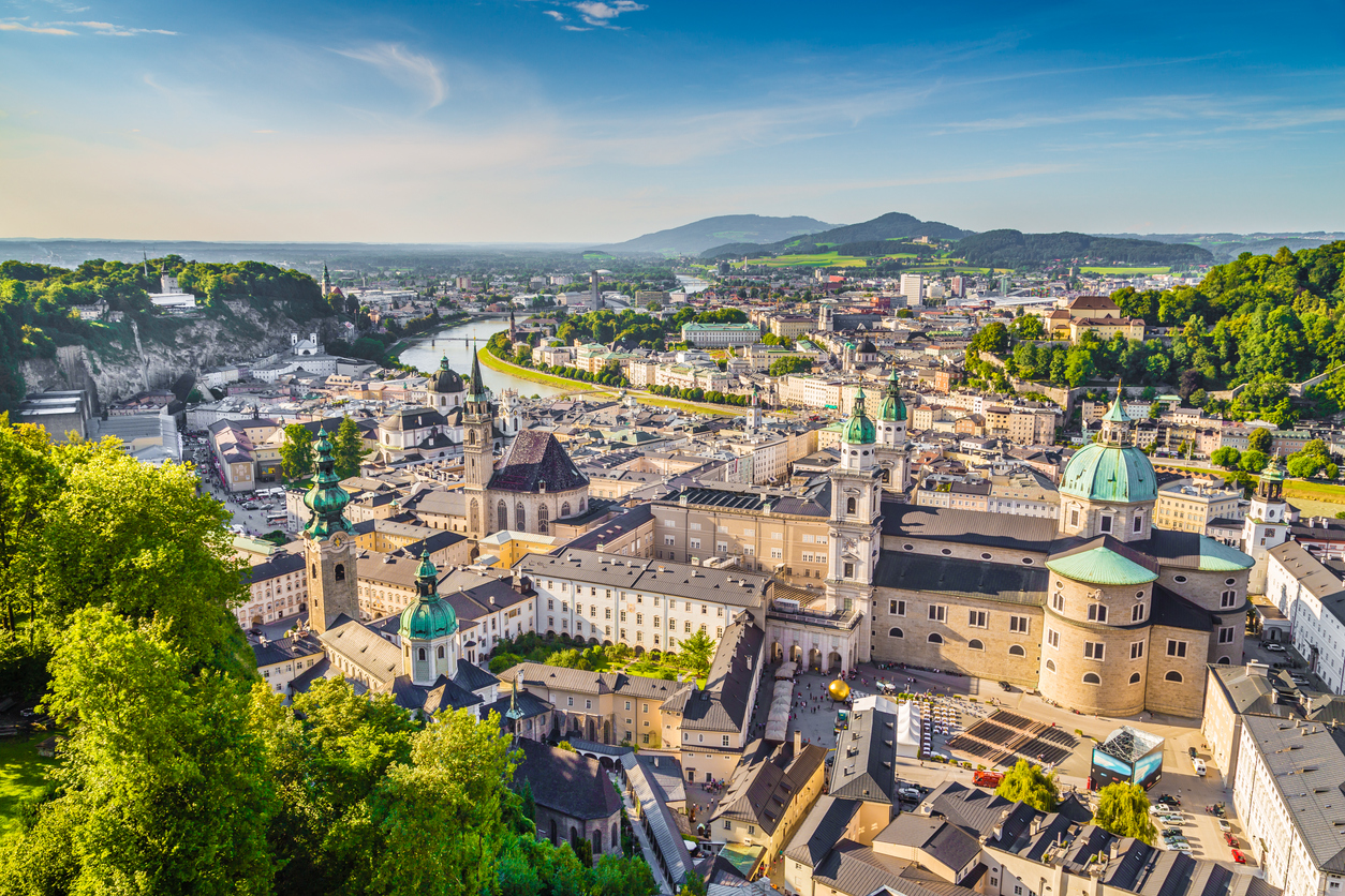 Luftaufnahme der Salzburger Altstadt mit Domkuppeln, Kirchtürmen und der geschwungenen Salzach.