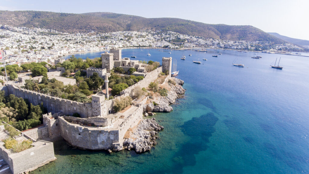 Luftaufnahme der Burg St. Peter an einer Felszunge mit Yachten in der Bucht.