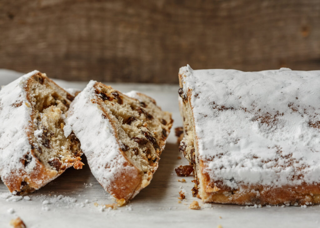 Aufgeschnittener Stollen mit Rosinen und dicker Puderzuckerschicht.
