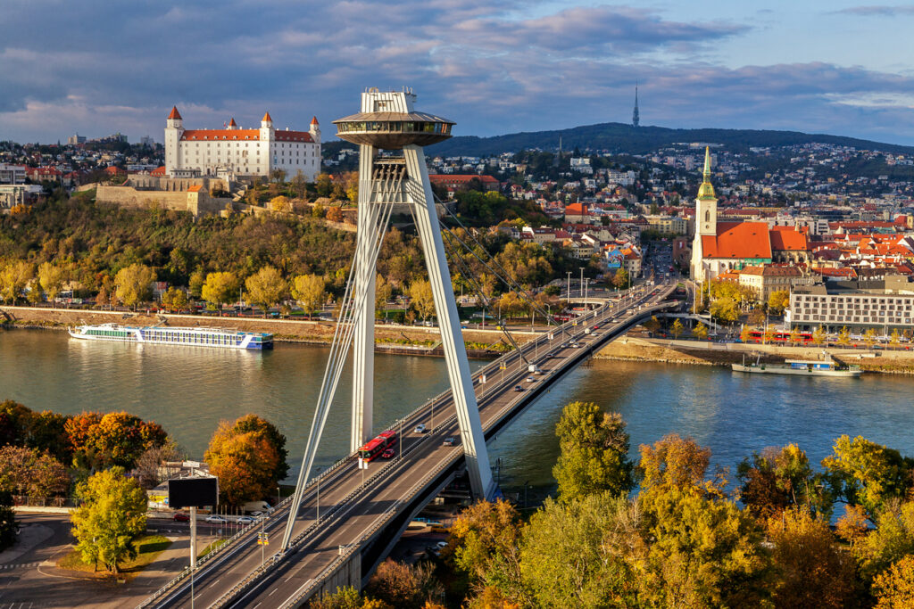 Panorama von Bratislava mit der Most-SNP-Brücke und UFO-Aussichtsplattform über der Donau, links die Burg und rechts der Martinsdom.
