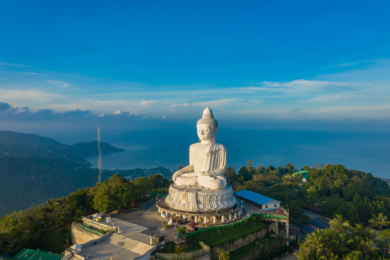 Weiße Buddha-Statue auf einem Hügel mit Meerblick