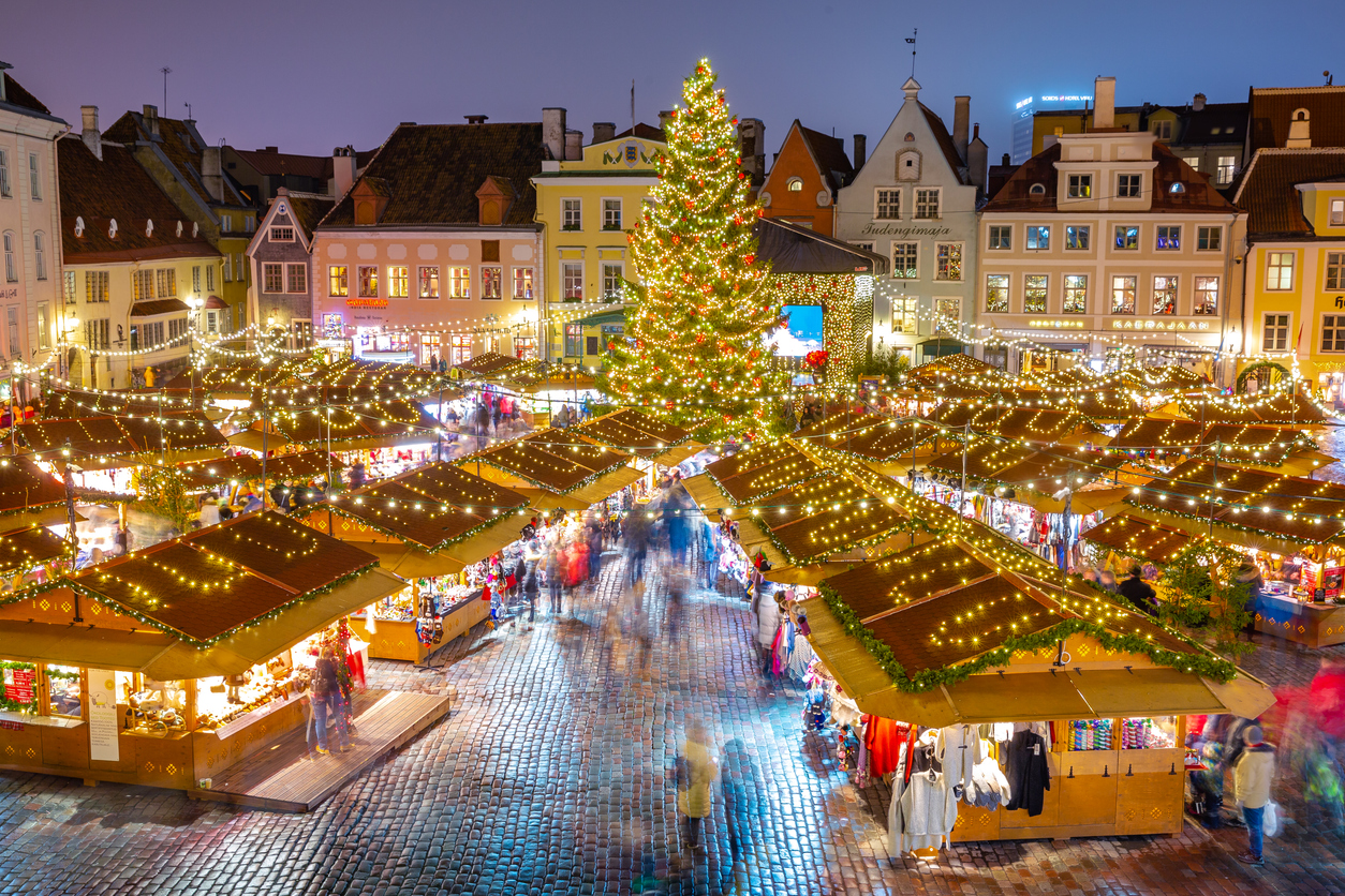Weihnachtsmarkt mit Budenlichtern und großem Baum im Zentrum von Tallinn.
