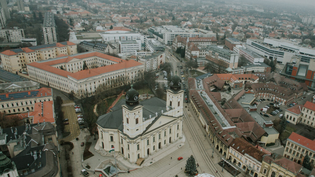Luftaufnahme der Großen Reformierten Kirche mit zwei Türmen am Kossuth tér, umgeben von Stadtvierteln.