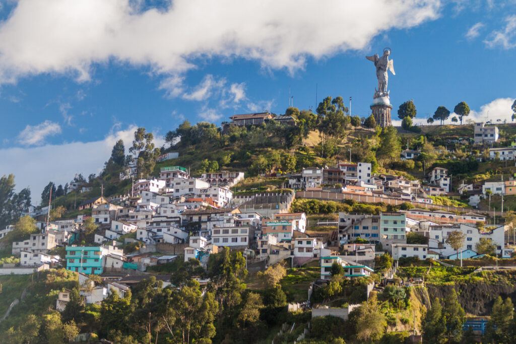 Häuser am Hügel El Panecillo mit großer Engelsstatue über Quito.