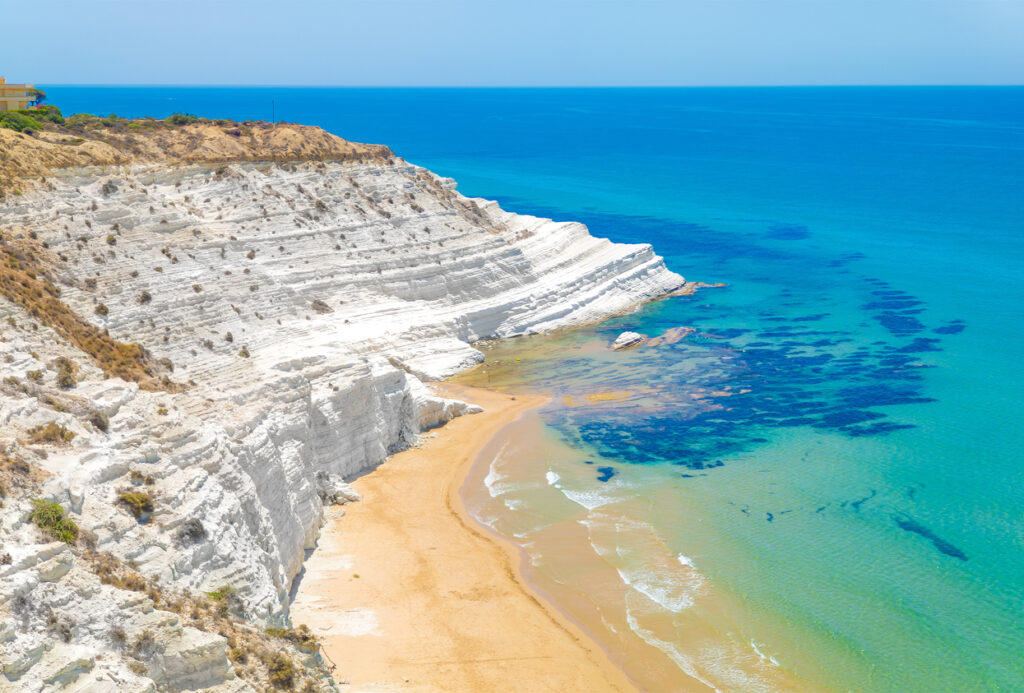 Strahlend weiße Kalksteinklippe Scala dei Turchi bei Agrigento mit sandiger Bucht und klaren türkisfarbenen Wellen.