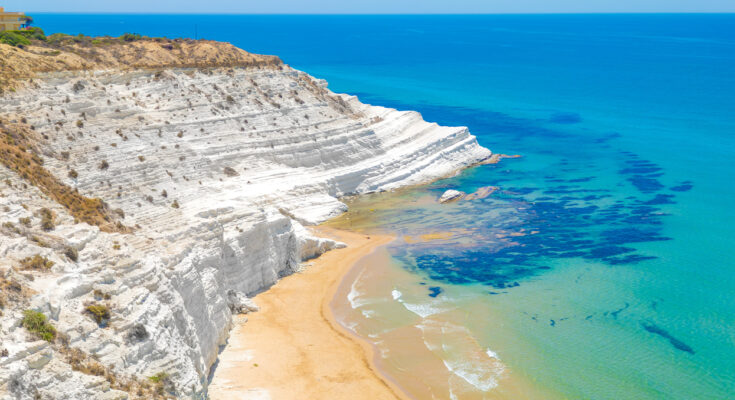 Strahlend weiße Kalksteinklippe Scala dei Turchi bei Agrigento mit sandiger Bucht und klaren türkisfarbenen Wellen.