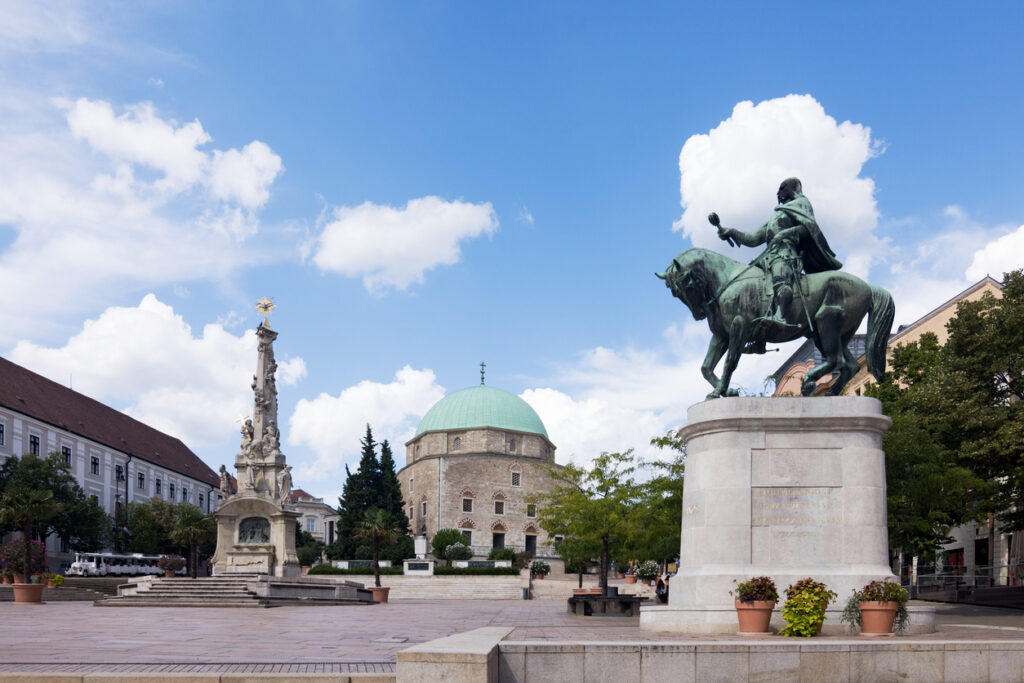 Weitwinkel vom Hauptplatz in Pécs mit Moschee, Dreifaltigkeitssäule und Reiterdenkmal.