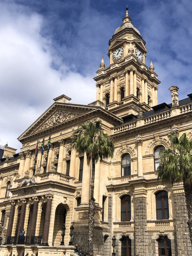 Historisches Rathaus mit Säulenfassade und großem Glockenturm.
