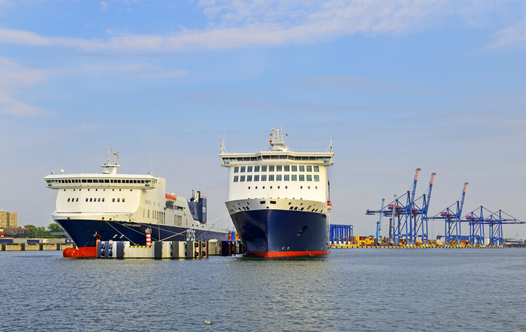 Zwei große Fähren liegen am Terminal vor Kränen im Hafen von Klaipėda.