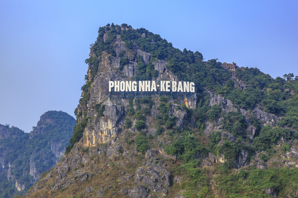 Weißer „Phong Nha–Kẻ Bàng“-Schriftzug an einer bewaldeten Karstwand.