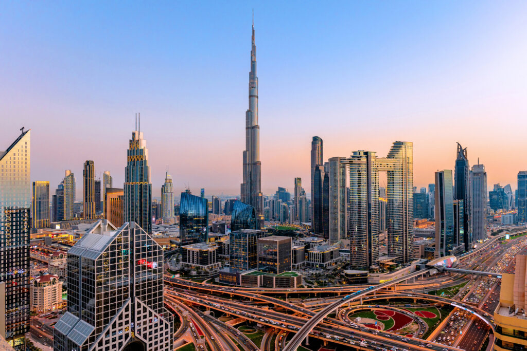 Weitwinkel mit Burj Khalifa und verschlungenen Autobahnen bei Sonnenuntergang.
