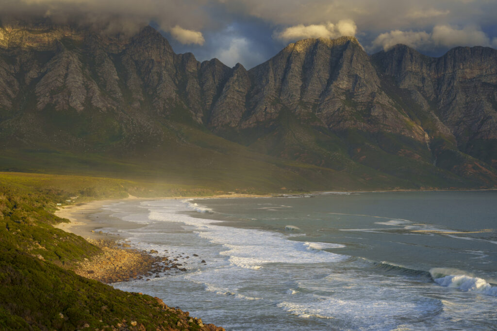 Felsige Atlantikküste mit hohen Bergen und brechenden Wellen.