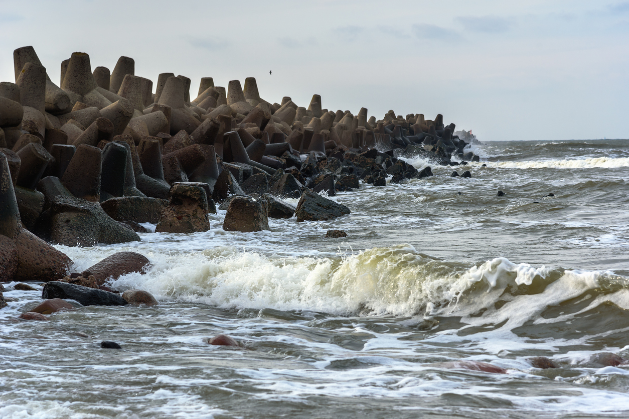 Nahaufnahme von Ostseewellen an massiven Beton Tetrapoden am Ufer von Liepāja.