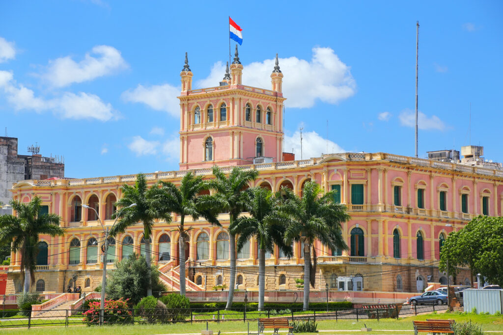 Palacio de López in Asunción mit Arkaden, Turm und paraguayischer Flagge.