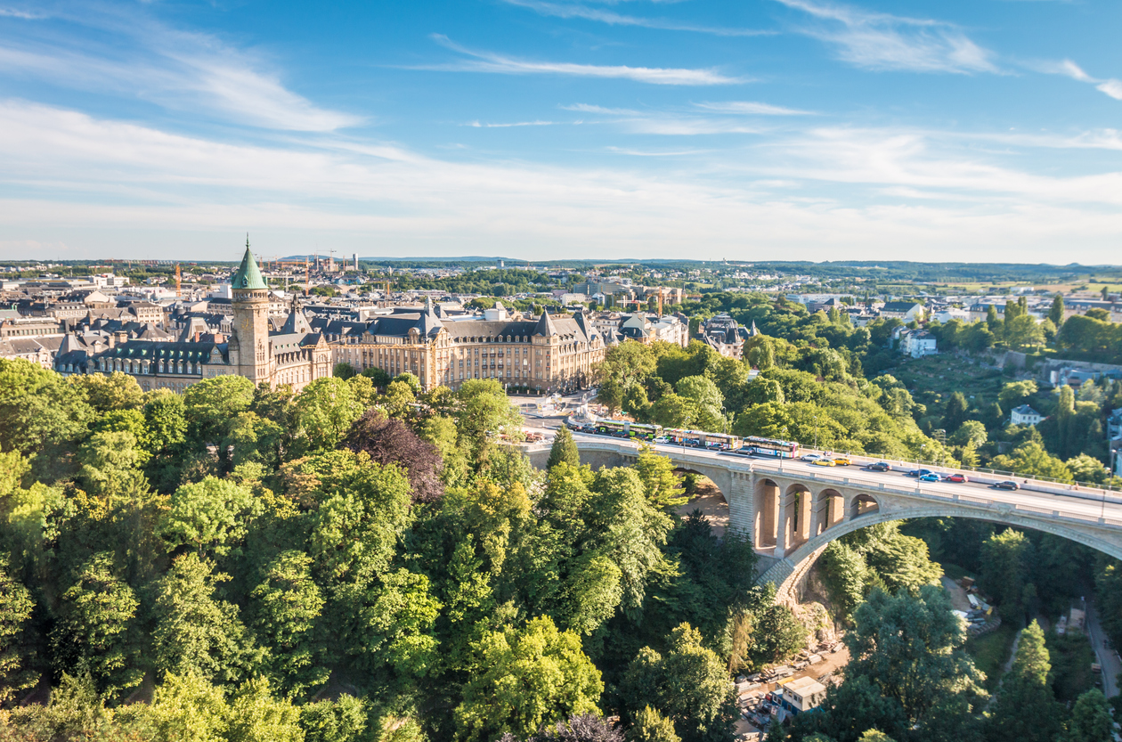 Große Steinbrücke führt über ein grünes Tal zu einem Turmgebäude.