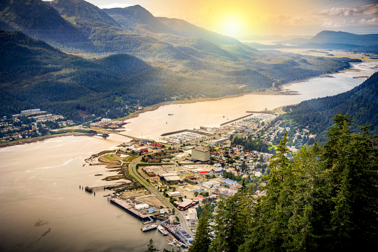 Panorama von Juneau mit Hafen, Straßen und umgebenden Bergen bei Sonnenuntergang.