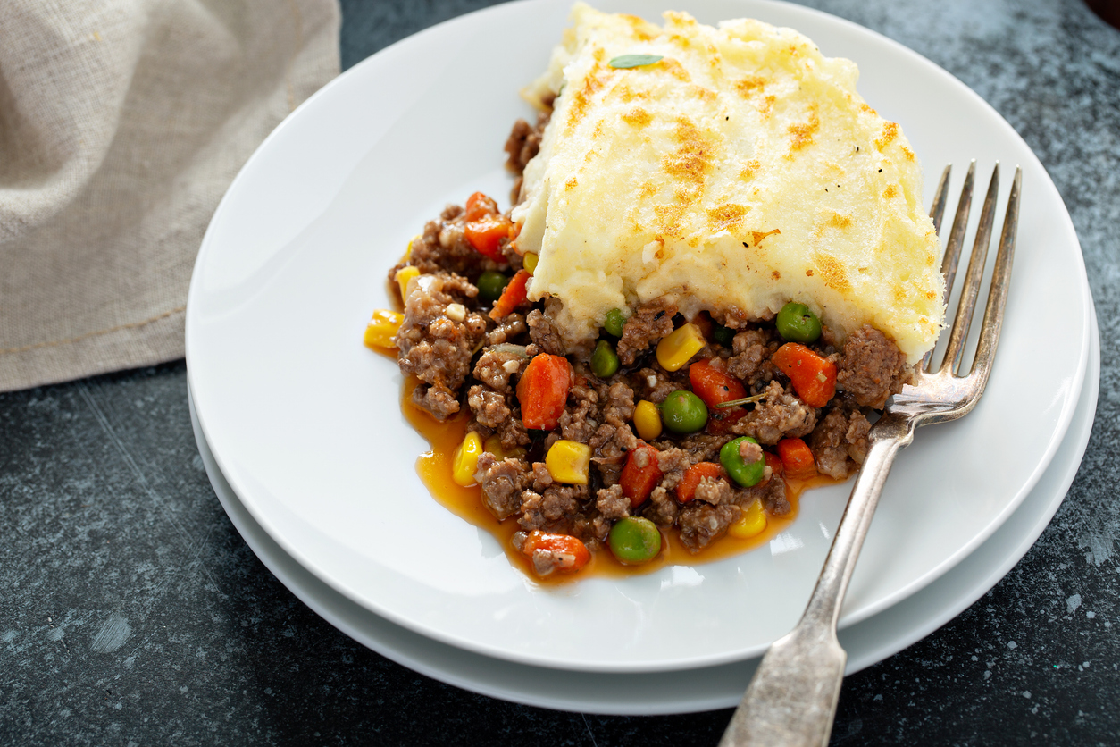 Teller mit einem Stück Shepherd’s Pie und bunter Hackfleisch-Gemüse-Füllung.