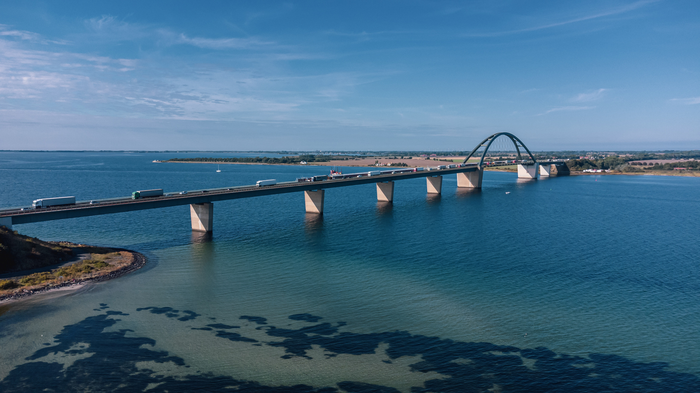 Blick auf eine lange Brücke über das Meer bei Fehmarn mit fließendem Verkehr und weitem Horizont.