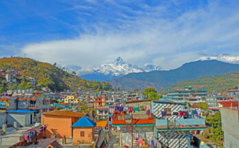 Panorama der Stadt Pokhara mit bunten Häusern und im Hintergrund dem markanten schneebedeckten Machapuchare.