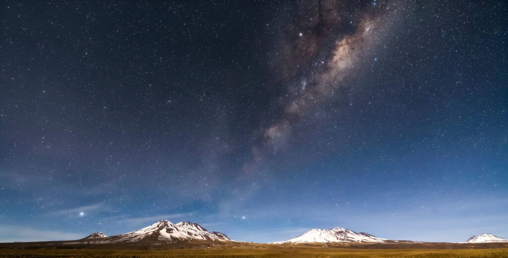 Die Milchstraße spannt sich über die Nachtlandschaft nahe San Pedro de Atacama, Chile.
