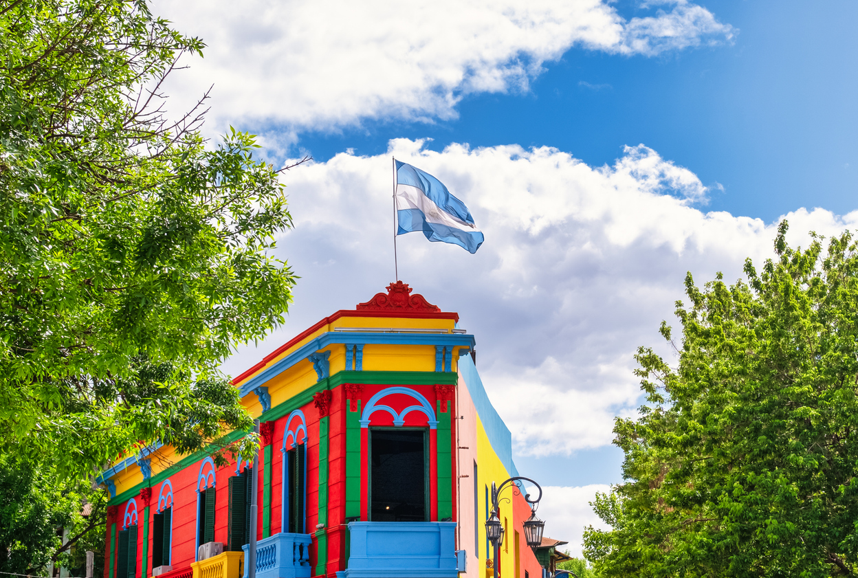 Farbenfrohes Eckhaus mit argentinischer Flagge im Viertel La Boca in Buenos Aires.