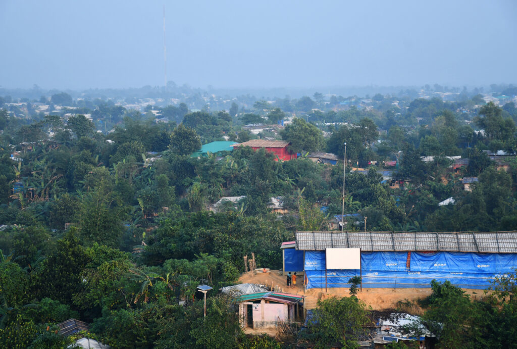 Blick auf ein dicht bewaldetes Gebiet mit verstreuten Hütten nahe Cox’s Bazar.