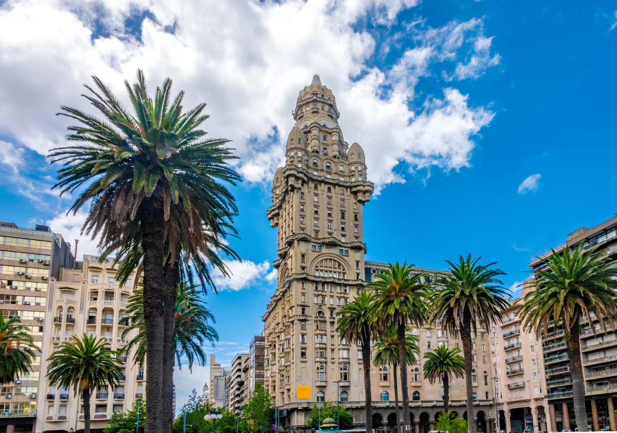 Blick auf den Palacio Salvo und Palmen an der Plaza Independencia in Montevideo, Uruguay.