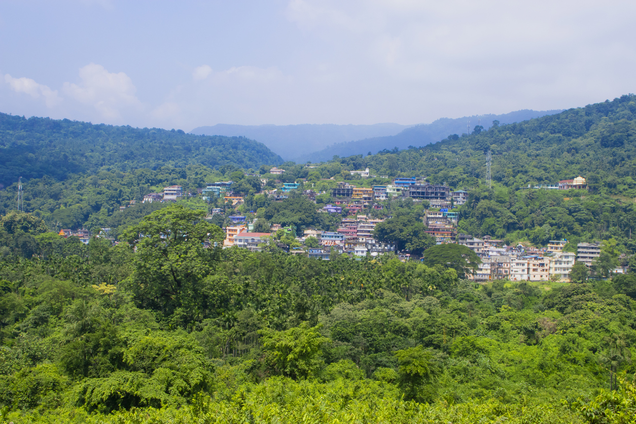 Die Stadt Sylhet breitet sich mit bunten Häusern über den dicht bewaldeten Hügeln aus.