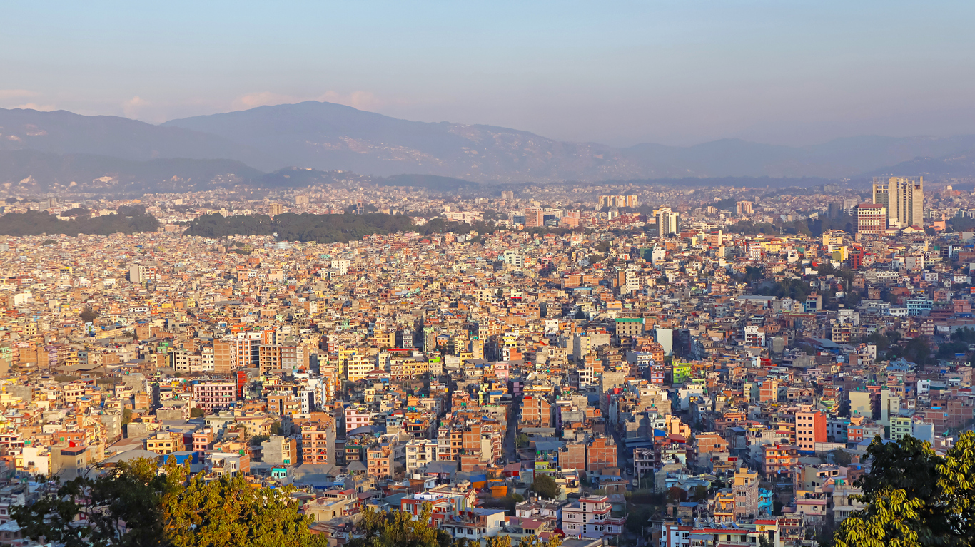 Eine Panoramaaufnahme zeigt das dichte Häusermeer von Kathmandu vor den Hügeln des Tals.