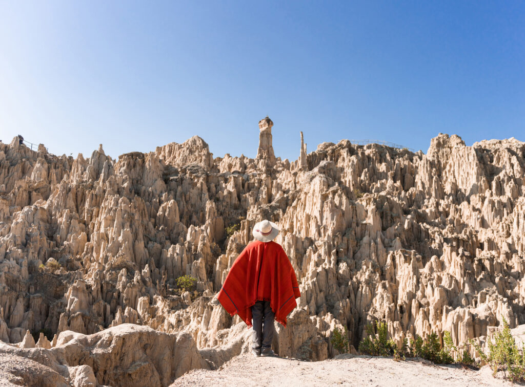 Eine Person steht vor bizarren Felsnadeln im Valle de las Ánimas nahe La Paz.