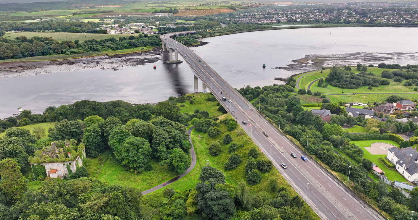 Luftaufnahme einer großen Straßenbrücke nahe Derry über einem breiten Fluss mit grüner Landschaft.