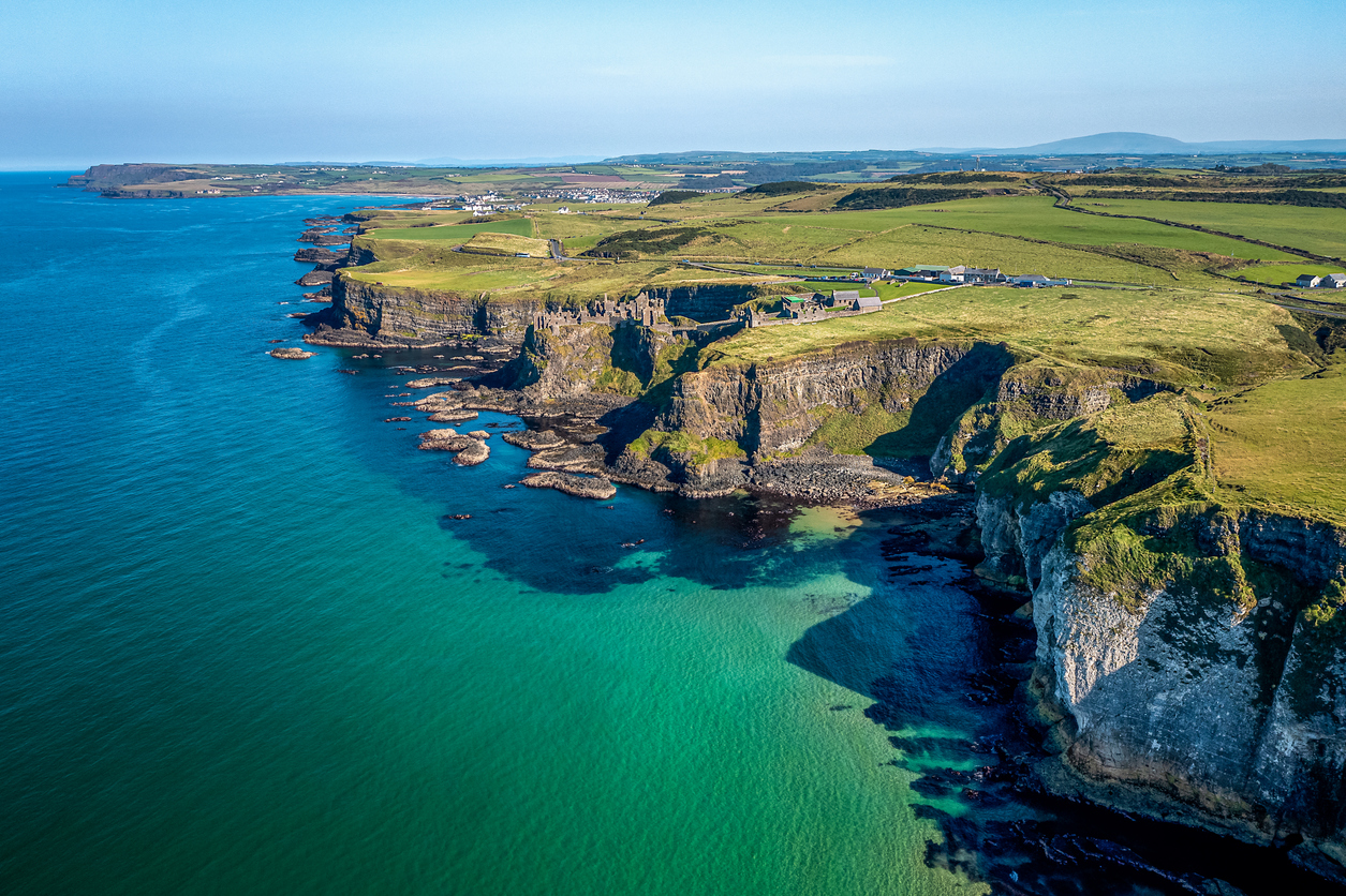 Blick auf die White Rocks bei Portrush mit hellen Klippen, grünen Wiesen und blauem Meer in Nordirland.