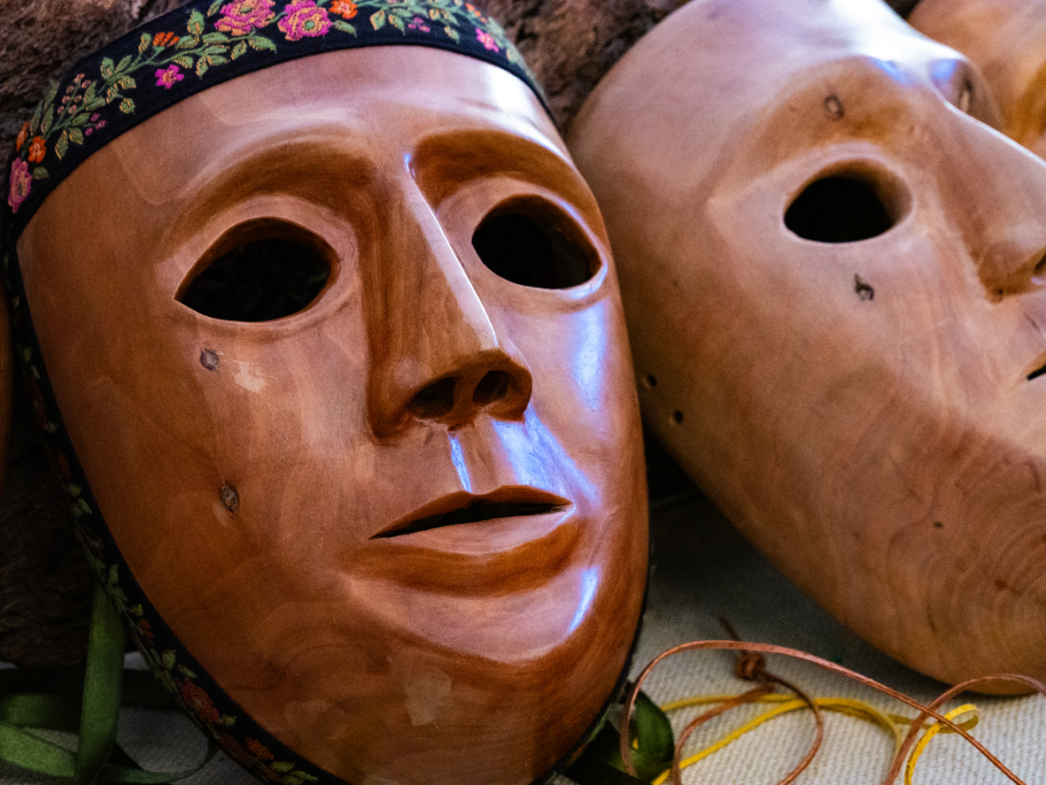 Nahaufnahme sardischer Holzmasken aus Bosa, die für traditionelle Feste und Rituale verwendet werden.